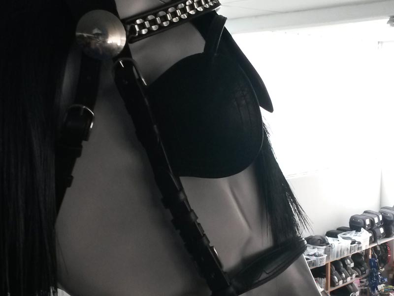 weiße Pferdeattrappe mit schwarzem Kopfstück mit Scheuklappen