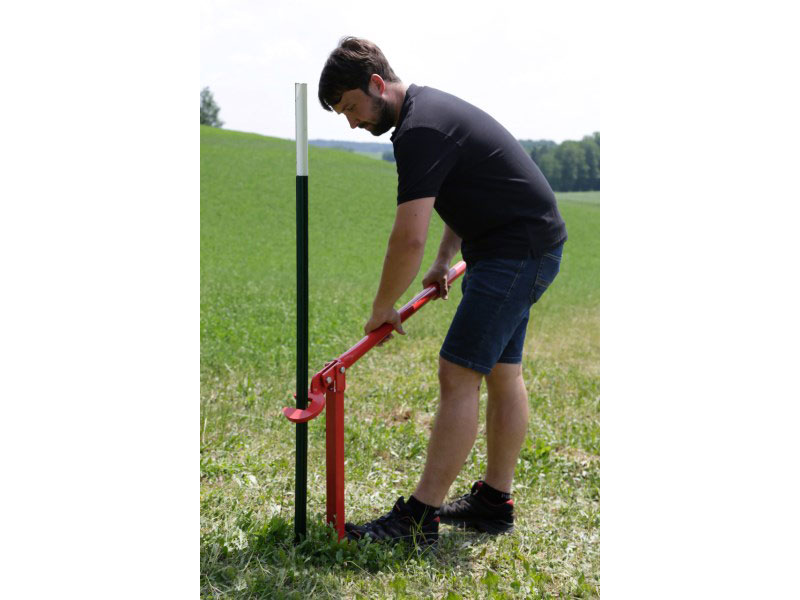 Mann mit rotem Zieher für T-Post Pfosten
